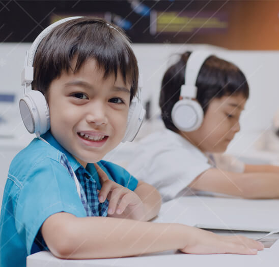 Boy smiling at computer in scratch coding class