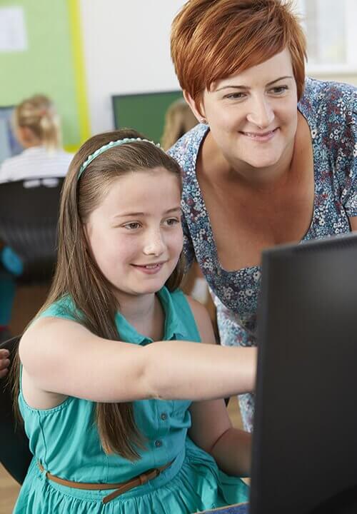 Teacher and student in class pointing at computer