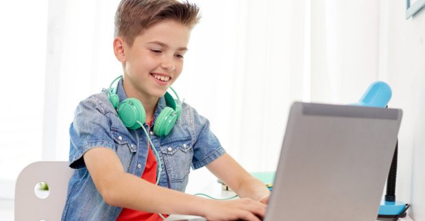 Teaching boy with headphones to code